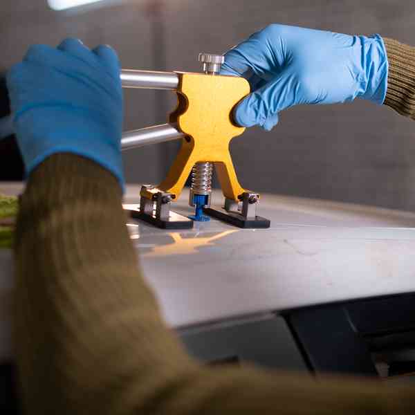 paintless dent repair tech working